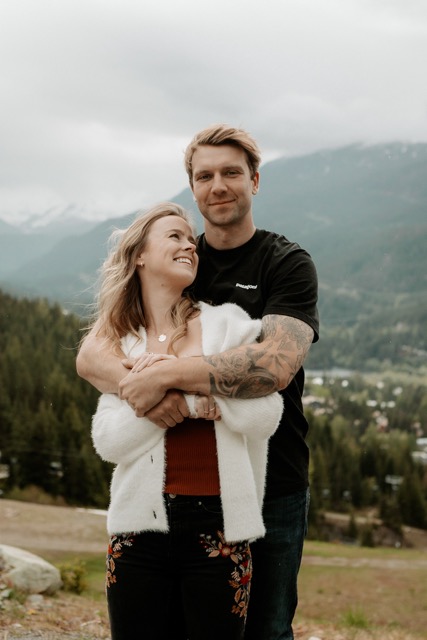 Couple sharing a playful piggyback moment on a mountain